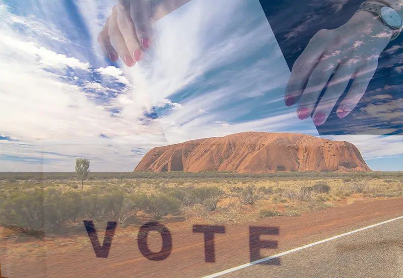 Person voting in Australian election, placing vote in Uluru