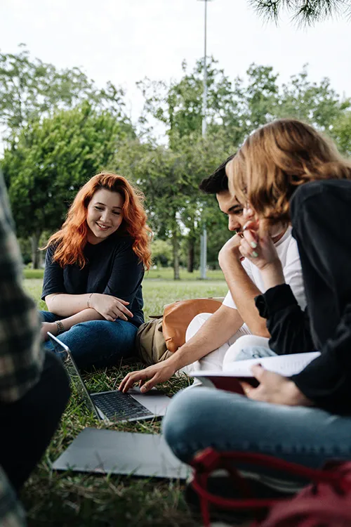 Students on an Australian student visa, sharing knowledge, sitting on campus grass